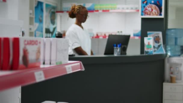 아프리카 미국인 약사가 선반에 의약품 약국에서 일하며 보조제를 판매하고 있습니다 — 비디오