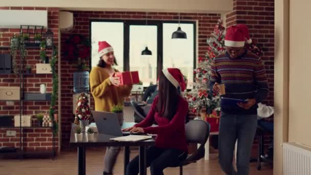 不同的人在寒假期间交换礼物 感受节日气氛 戴着圣诞礼帽 赠送礼物 用节日装饰和彩灯庆祝圣诞节 — 图库视频影像
