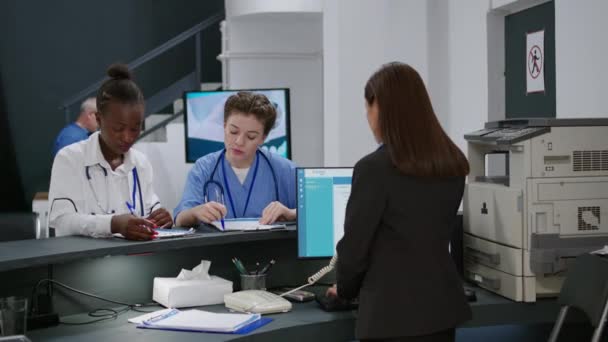 Multietnický Lékařský Tým Analyzuje Kontrolní Formuláře Registračním Pultu Hale Nemocniční — Stock video