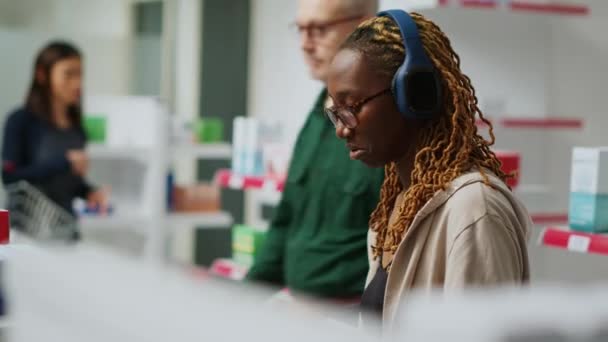 Африканський Клієнт Який Вивчає Коробки Ліками Полицях Аптеки Дивиться Рецепт — стокове відео
