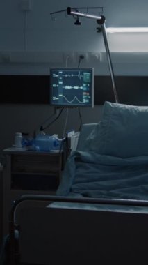 Dikey video: Tıbbi malzemeler, yatak, monitör, bilgisayar, tekerlekli sandalye ile dekore edilmiş boş acil sağlık servisi koğuşu. Tedavi için yeniden canlandırma odası. Hastalık, ameliyat iyileştirme, klinik tedavi.