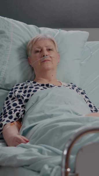Вертикальное Видео Портрет Больного Лежащего Больничной Койке Пациента Смотрящего Камеру — стоковое видео