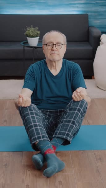 Vertikales Video Alter Mensch Sitzt Lotusposition Mit Geschlossenen Augen Auf — Stockvideo