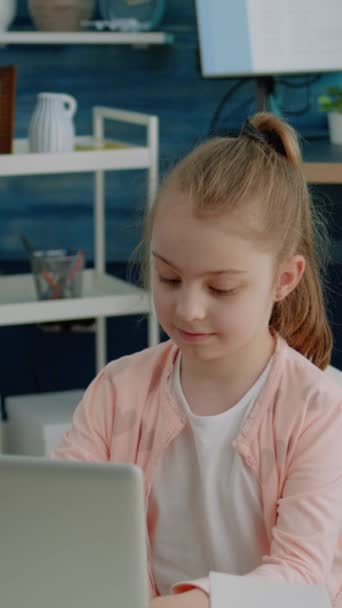 垂直录像 女学生用笔记本电脑做作业和微笑的肖像 有现代口吃的幼儿 可供在线远程教育和课程用 他们看着摄像机 心情愉悦 — 图库视频影像