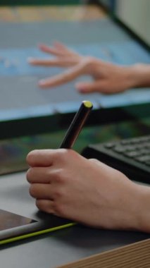 Dikey video: Medya uzmanlarının ellerini stylus ile grafik tablet kullanarak kapat ve stüdyodaki fotoğraf rötuşlama yazılımı için ekranda dokun. Rötuş ekipmanıyla çalışan resim düzenleyici