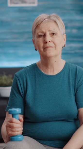 Вертикальное Видео Портрет Пожилой Женщины Держащей Гантели Дома Готовящейся Занятиям — стоковое видео