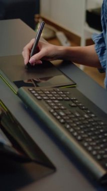 Dikey video: Fotoğraf stüdyosu ekipmanlarını ve teknolojiyi kapatın. Sanatçının elleri dokunmatik ekran monitörü, grafik tablet ve stil üzerinde rötuş yazılımı kullanıyor. Resimleri düzenleyen kadın