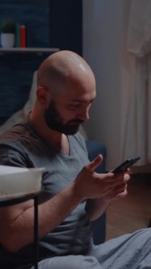Dikey video: Yalnız, çaresiz ve umutsuz bir adam, akıllı telefondaki dijital tahliye uyarısı yüzünden çaresizce ağlayan üzgün bir adam. Ödenmemiş kira uyarısı nedeniyle depresyonda olan kiracı