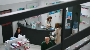 Eczane tezgahından ilaç ve ilaç alan Afrikalı Amerikalı bir müşteri eczacıyla ilaç ve uyuşturucu hakkında konuşuyor. Eczanede ilave malzemeler için para ödeyen kadın..