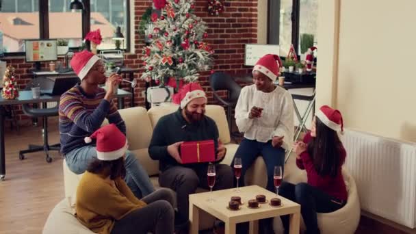 Різноманітні Співробітники Обмінюються Несподіваними Подарунками Різдвяній Вечірці Офісі Ялинкою Прикрасами — стокове відео
