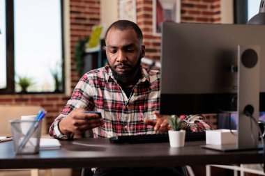Genç yetişkinler çevrimiçi perakende mağazasından alışveriş yapıyor. Uzaktan kumandalı bir işte çalışırken kredi kartıyla indirimli alışveriş yapıyor. Freelancer elektronik ödeme işlemlerini yapıyor ve uzaktan evde çalışıyor..
