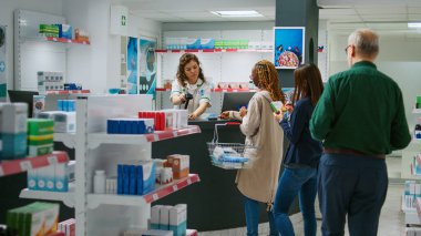 İlaç ve uyuşturucuya cep telefonu ile ödeme yapan çeşitli müşteriler, eczane tezgahında akıllı seğirmeler ya da kredi kartları. Eczaneden ilaç ürünleri ve vitaminler satın almak.