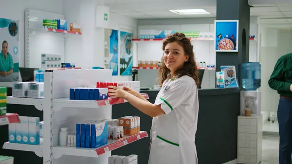Lächelnde Apothekerin Untersucht Tablettenpackungen Kunden Mit Krankheiten Und Verschreibungspflichtigen Medikamenten — Stockfoto