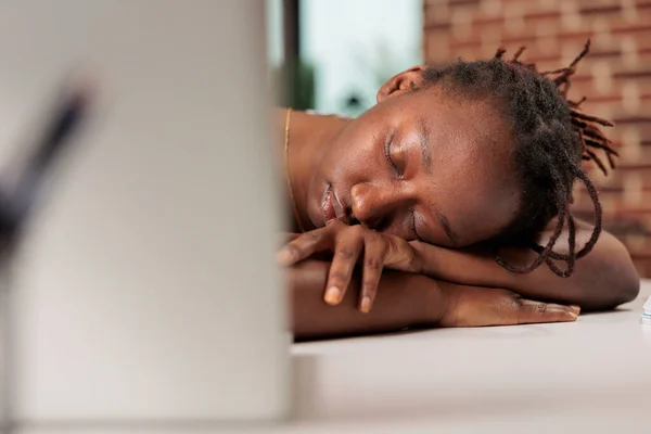 Stressed remote worker sleeping on table during day, sleepy overworked freelancer, professional burnout. Tired student lying on desk, close view on face, exhausted employee having break