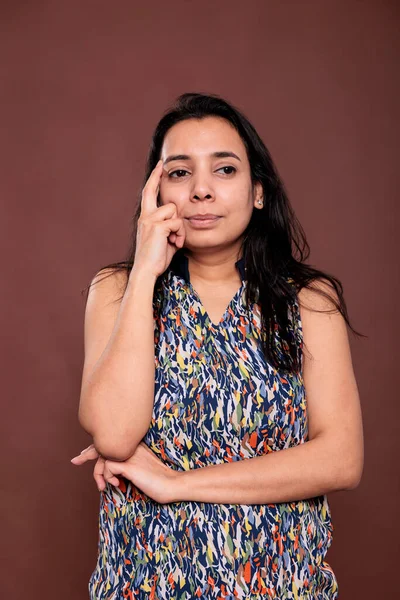 富有洞察力的印度女人侧视着肖像 模特儿摆出姿势 把手指放在脸上 多愁善感的人 面容可疑 前视演播室中镜头 — 图库照片