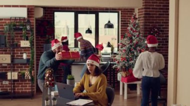 Noel ağacı ve ışıklarla süslü ofiste hediye alışverişi yapan şenlikli insanlar, kış tatilinde hediyeler veriyorlar. Noel arifesini dekorasyon ve süslemelerle kutluyoruz.
