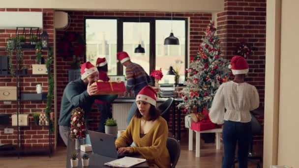 Festliche Menschen Tauschen Geschenke Geschmückten Büro Mit Weihnachtsbaum Und Lichtern — Stockvideo