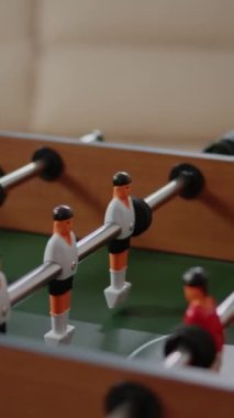 Dikey video: Ofiste eğlenceli aktiviteler ve eğlence için langırt masasını kapatın. Futbol maçıyla oynamak, gol atmak için oyuncular, işten sonra iş arkadaşlarıyla içki içmek. Futbol.