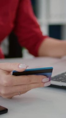 Dikey video: Başlangıç çalışanı dizüstü bilgisayarında kredi kartıyla online alışveriş yapıyor, bankacılık parasıyla satış yapıyor. Ofis çalışanı, ticari kalkınma için işlem yapıyor. Kapat..