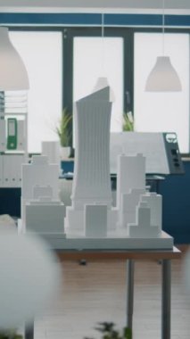 Dikey video: Bina modeli ve planları olan boş bir mimarlık bürosu. Uzayda kimse mimari yapısına sahip gayrimenkul tasarımı ve geliştirme için kullanılmamış..