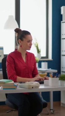 Dikey video: Finansal uzmanlık araştırma projesine sahip iş kadını, e-ticaret satış grafikleriyle başlangıç ofisinde bilgisayar başında çalışıyor. Yönetici olarak çalışan bir şirket çalışanı..
