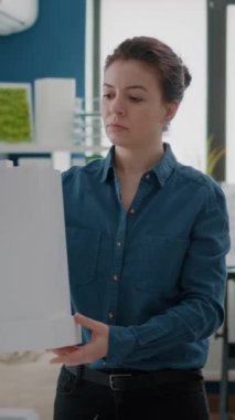 Şehir proje yapısı yaratmak için bina modelini analiz eden kadın mimar portresi. Endüstriyel müteahhit, inşaat inşaatı planlamak ve tasarlamak için maket planına bakıyor..