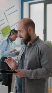 Dikey video: Adam mühendis, yapı modeli ve maquette ile tablet üzerinde mimari plan tasarlıyor. Emlak inşaat planını geliştirmek için şehir projesinde çalışan bir mimar. Sanayi