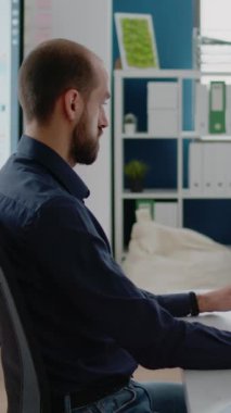 Dikey video: Ofiste bilgisayar üzerinde çalışan iş adamının portresi. Finans, ekonomi stratejisi ve kalkınma için oran tablosu olan bir şirket çalışanı. Pazarlama girişimcisi
