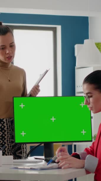 垂直ビデオ 孤立したクロマキーとモックアップテンプレートを持つコンピュータを使用して モニター上の緑の画面について話している企業の人々 空白のコピースペースの背景を持つ女性同僚が表示されます — ストック動画