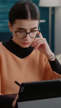 Dikey video: Üniversite öğrencisi Stylus ile dijital tablet üzerine notlar alıyor, online okul sınıfı için eğitim kursu almak için cihaz kullanıyor. Uzaktan ödeve hazırlanmak için aygıt üzerinde çalışan kadın
