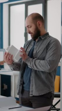Dikey video: Adam mühendis, ofis modeline sahip inşaat planları tasarlıyor. Kentsel gelişim ve endüstriyel mimari yaratmak için maket ve skeç kullanan mimar.