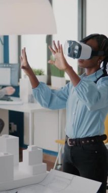 Dikey video: Yapı modeli ve inşaat düzeni tasarlamak için vr gözlük kullanan mimar. Sanal gerçeklik kulaklığıyla çalışan kadın müteahhit emlak yapısını planlamak, kentsel proje yaratmak için çalışıyor