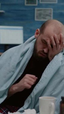 Dikey video: Hasta adamın burnu peçeteyle akarken ve hastalık yüzünden hapşırırken yakın çekim. Soğuk algınlığı ve soğuk algınlığı olan bir yetişkin. Virüs belirtileri gösteren hasta biri..