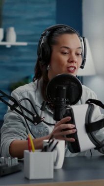 Dikey video: İçerik oluşturucu video kaydederken modern VR kulaklığı tanıtıyor. Ünlü sosyal medya etkileyicisi, yüksek teknolojili gözlüğü izleyiciye incelerken tavsiye videosu yapıyor..