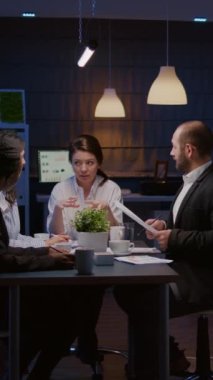 Dikey video: İş kadını lederi konferans masasında oturmuş şirket takım çalışması planlama şirketi yönetim sunumuyla tartışıyor. Çeşitli çok ırklı iş arkadaşları beyin fırtınası yaparak