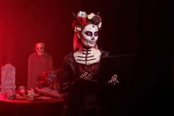 Модель Хэллоуина Использующая Ноутбук Студии Выглядящая Леди Святой Смерти Санта — стоковое фото