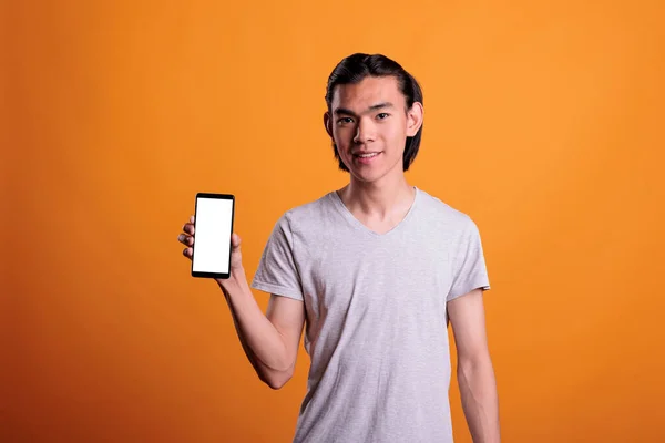 Młody Azjata Prezentujący Smartfona Pustym Ekranem Uśmiechnięty Nastolatek Trzymający Telefon — Zdjęcie stockowe