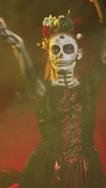 垂直ビデオ 砂糖頭蓋骨のボディアートと花の冠を持つ美しい女性は サンタマエルテとして死の衣装に身を包んだ ディオス ムエルトスハロウィンアート聖なるメキシコの伝統を祝うために — ストック動画
