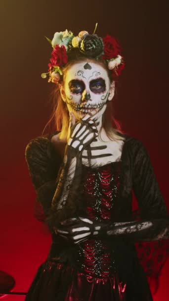 垂直ビデオ Santa Muerteモデルはスタジオで思考の顔をして 死んだメキシコの休日を祝うために思慮深く 情熱的に見えます 女の描写聖なるカヴァレラカトリーナハロウィンエンティティ — ストック動画