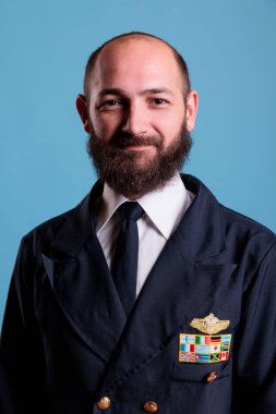 Üniformalı gülümseyen bir pilot, yakın plan portre, kameraya bakan bir uçak kaptanı. Profesyonel takım elbiseli orta yaşlı bir havacı, uçuş ekibi üyesi.