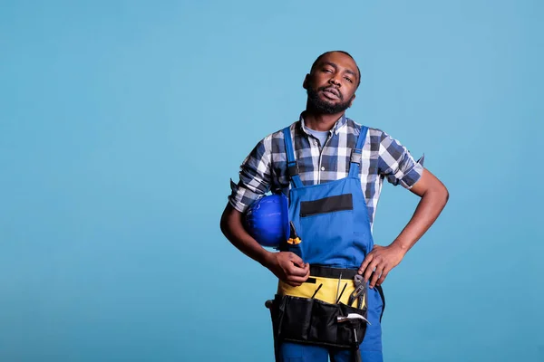 Afrikalı Amerikalı Inşaat Işçisi Stüdyoda Mavi Arka Planda Kameraya Ciddi — Stok fotoğraf