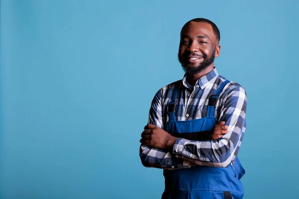 Portret Afrykańskiego Amerykańskiego Budowniczego Mundurze Pozującego Pewnie Niebieskim Tle Uśmiechnięty — Zdjęcie stockowe