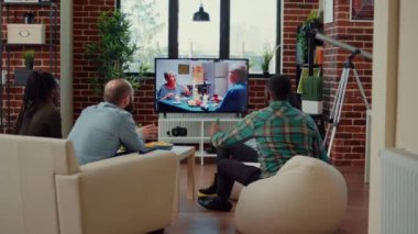 TV kanalında film izleyen, bira içen ve eğlence toplantısında abur cubur yiyen çok ırklı bir arkadaş grubu. Mutlu insanlar televizyon programında ya da sinema filminde eğleniyor..