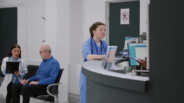 Portrait Medical Assistant Analyzing Checkup Papers Hospital Reception Desk Working — Αρχείο Βίντεο