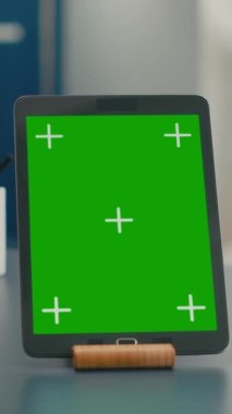 Dikey video: Ofis işi için kullanılan yeşil ekran krom anahtar görüntüsü ile tablet bilgisayarın kapatılması. İskandinav aletini kullanarak iletişim projesinde çalışan serbest çalışan kadın.