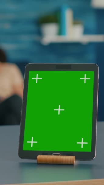 垂直录像 两个女人坐在沙发上谈论数字技术 办公室配备了独立的平板电脑 桌上摆放着绿色屏幕彩色键的模拟显示屏 — 图库视频影像