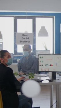 Koronavirüs salgınında dirsek teması yapan iki iş arkadaşı, virüs bulaşmasını önlemek için tıbbi maske takıyor. Şirketin adamı.