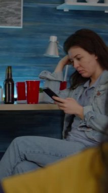 Dikey video: Bir grup karışık ırktan insan gece geç saatlerde oturma odasında cep telefonundan online haberleri araştırıyor. Sürpriz parti sırasında çok ırklı arkadaşlar film izliyorlar.