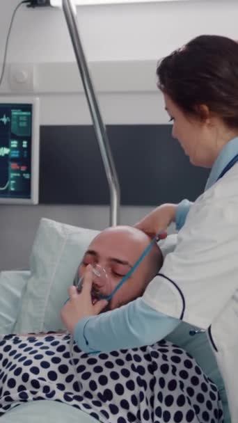 Κατακόρυφο Βίντεο Άρρωστος Άντρας Ξεκουράζεται Στο Κρεβάτι Ενώ Γυναίκα Γιατρός — Αρχείο Βίντεο