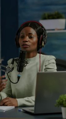 Dikey video: Afrikalı kadın vlogger canlı yayın sırasında ev podcast stüdyosundaki yaşam tarzını kameraya kaydediyor. Online prodüksiyon internet yayın sunucusu canlı yayın yapıyor.